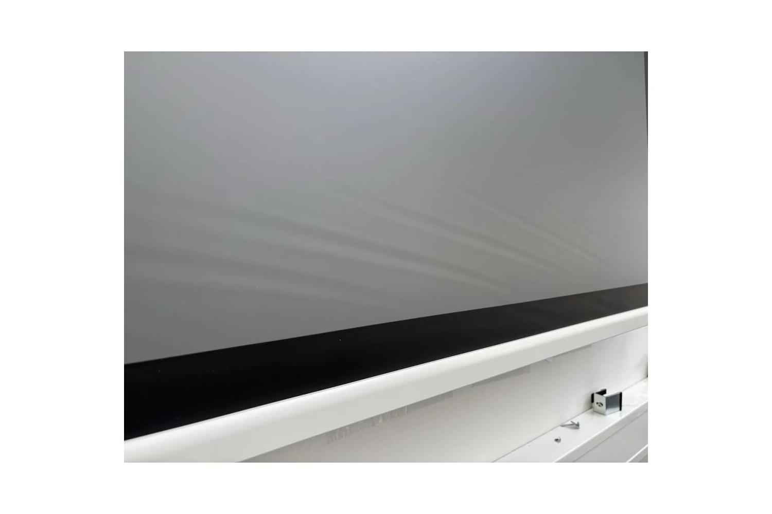 B-Ware DELUXX Cinema Electric Tension Screen: Leichte Wellen im Tuch direkt über der Abschlussleiste