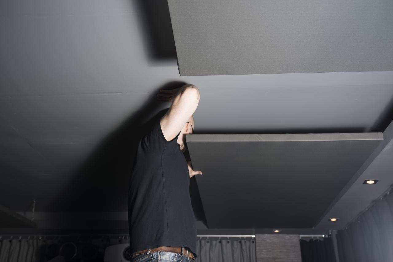 Als letzter Schritt wurden die Deckensegel für eine akustische Optimierung des Raumes angebracht Person installiert Akustikpaneel an der Decke.