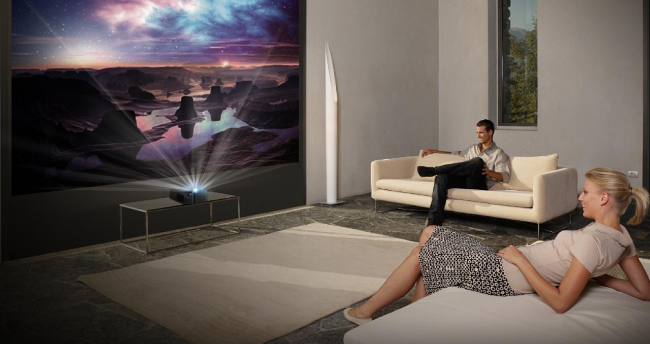 Die einfache Art der Projektion mit dem LG Adagio Menschen schauen Film mit Projektor im Wohnzimmer.