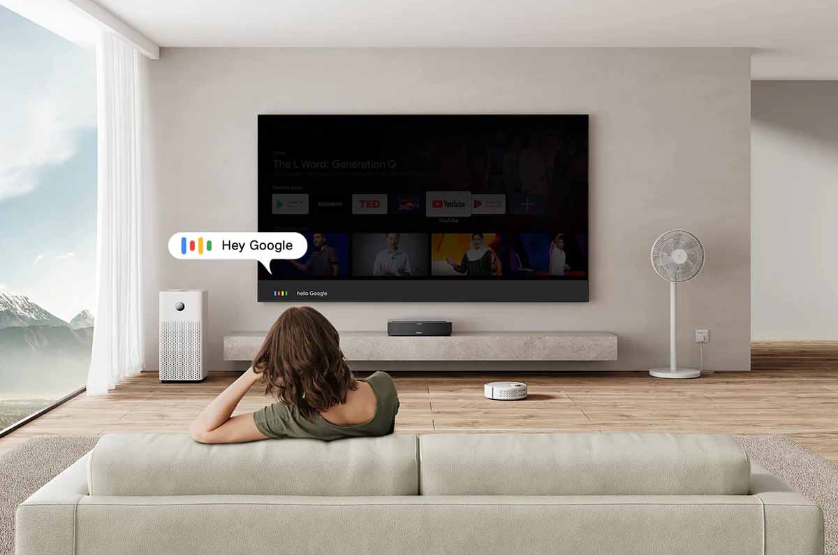 Person steuert Fernseher mit Sprachbefehl.