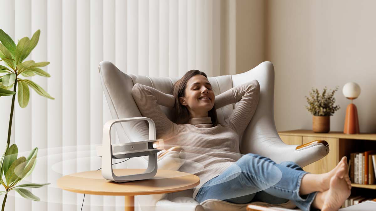 Frau entspannt mit Beamer im Wohnzimmer.