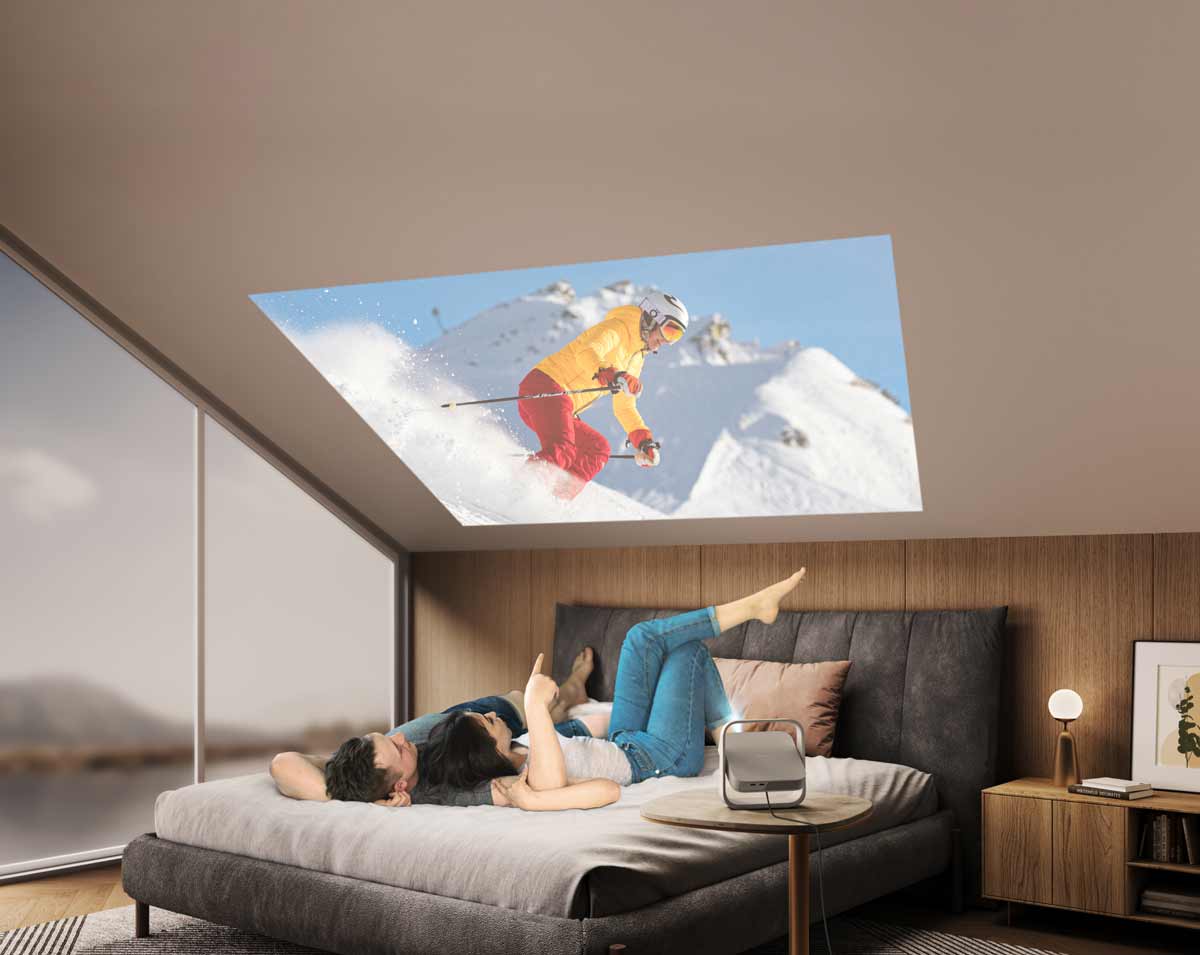 Paar schaut Ski-Video mit Beamer an.