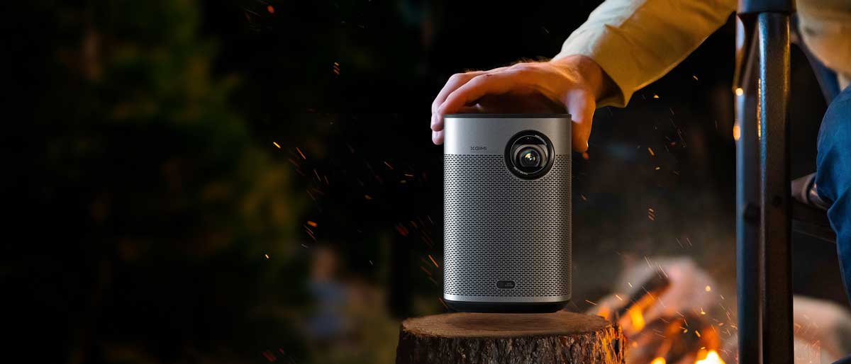 Beamer im Freien neben einem Lagerfeuer.