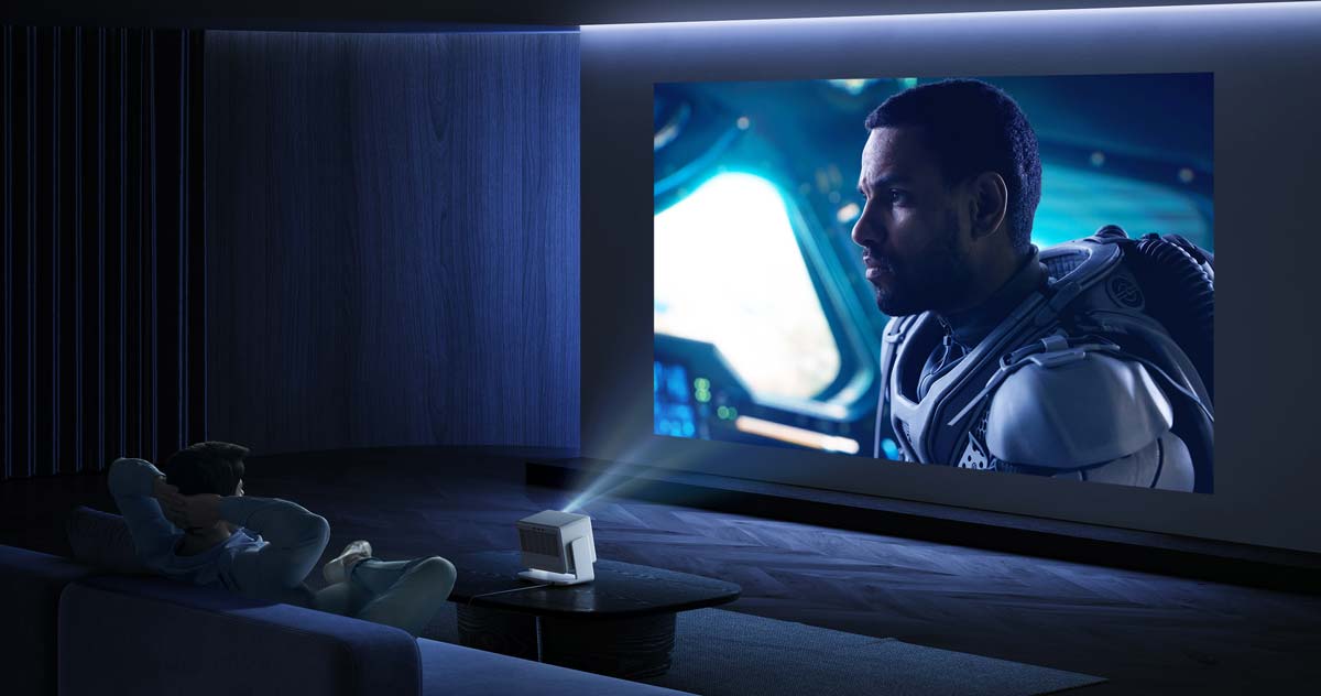Person schaut Film mit Beamer im Wohnzimmer.