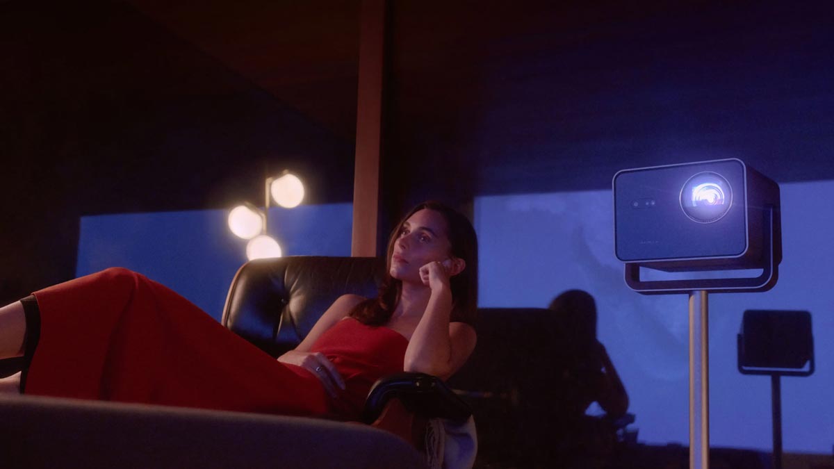 Frau entspannt mit Beamer im Hintergrund.