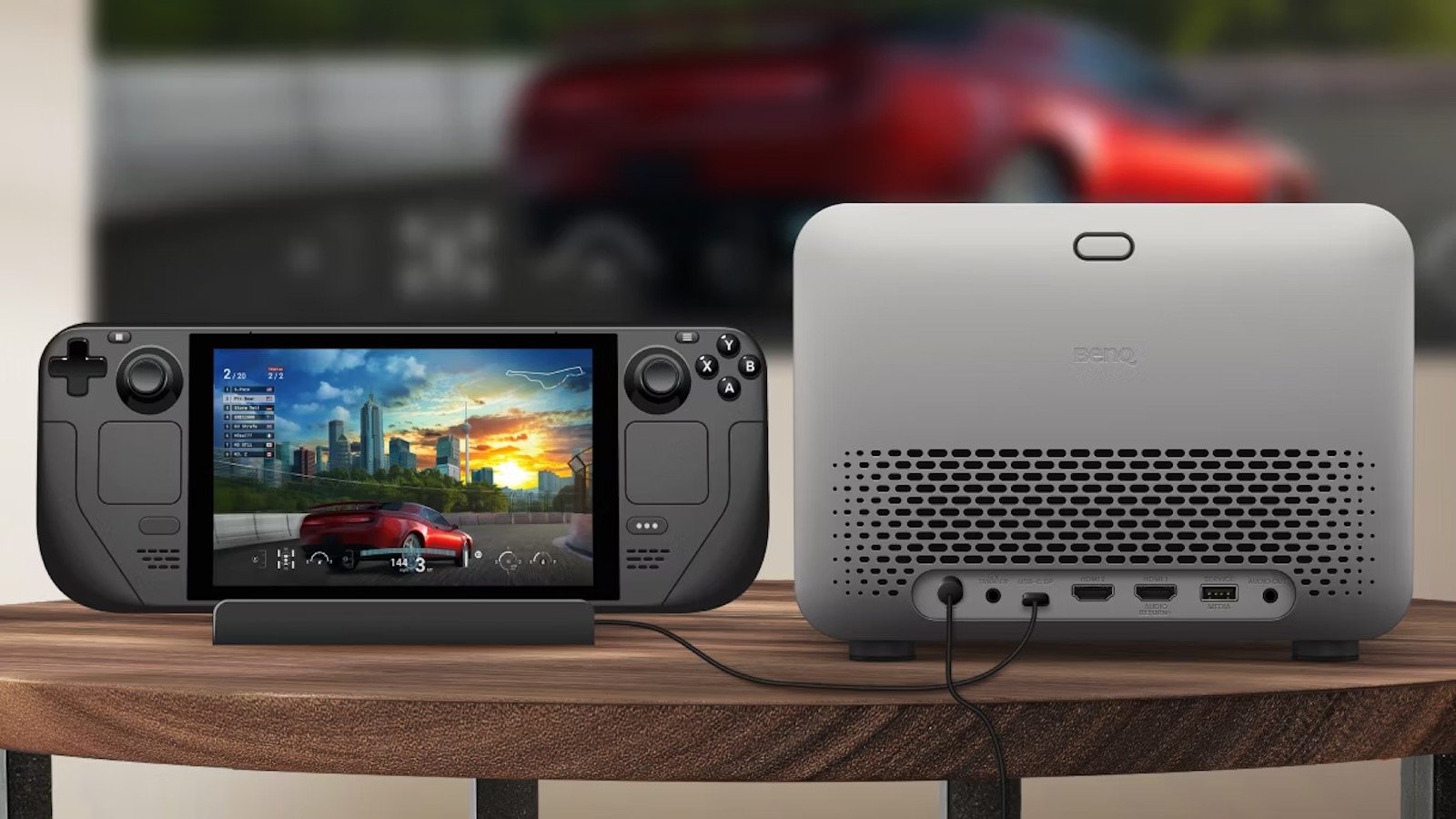 Handheld-Konsole und Beamer auf Holztisch.