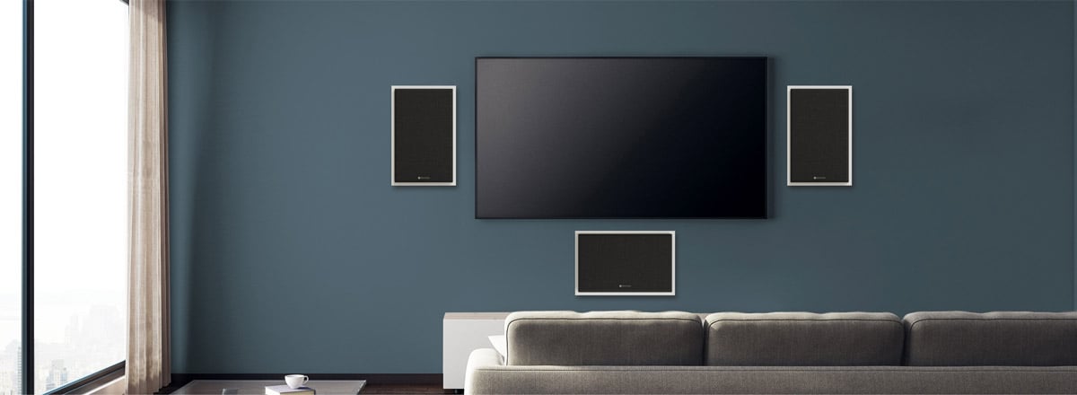 Heimkino mit Beamer und Lautsprechern an der Wand.