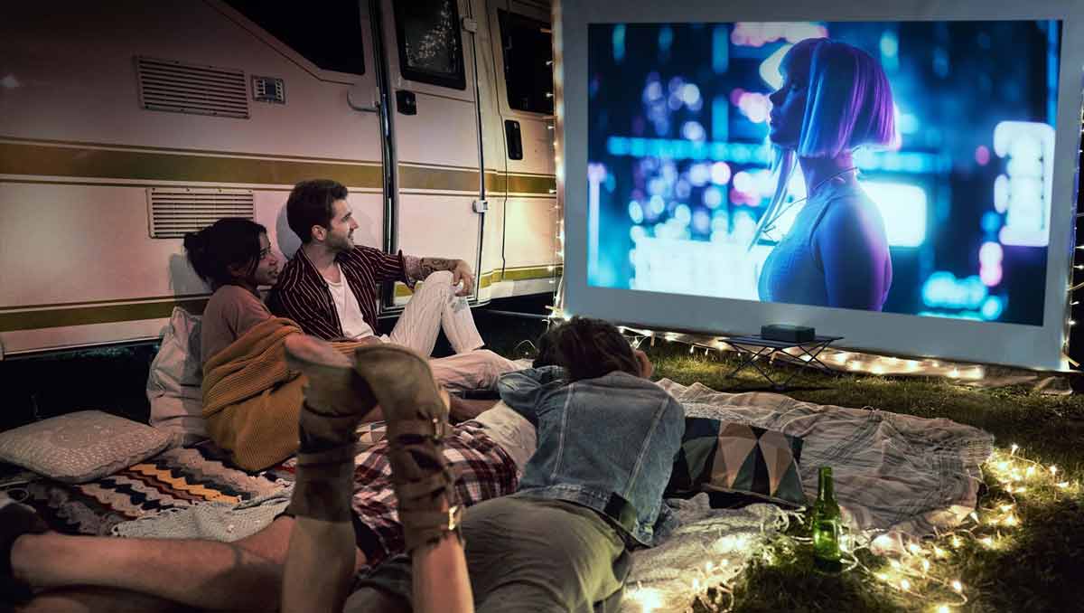 Camping-Filmabend mit Beamer und Freunden draußen.