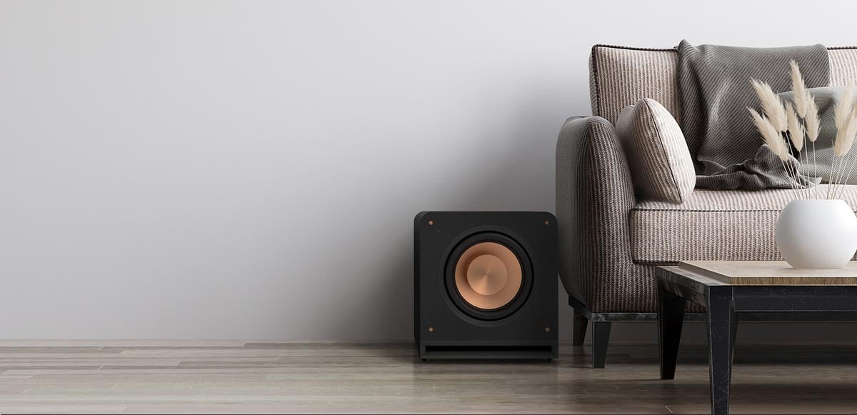 Subwoofer neben Sofa in modernem Wohnzimmer.