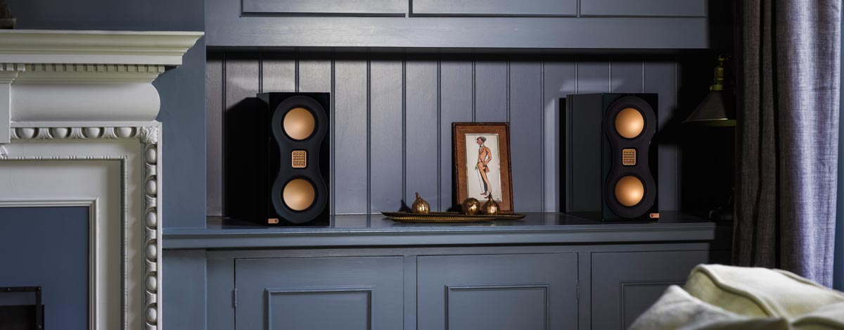 Lautsprecher auf Regal mit Dekorationen.