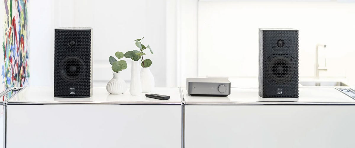 Lautsprecher und Verstärker auf weißem Tisch.