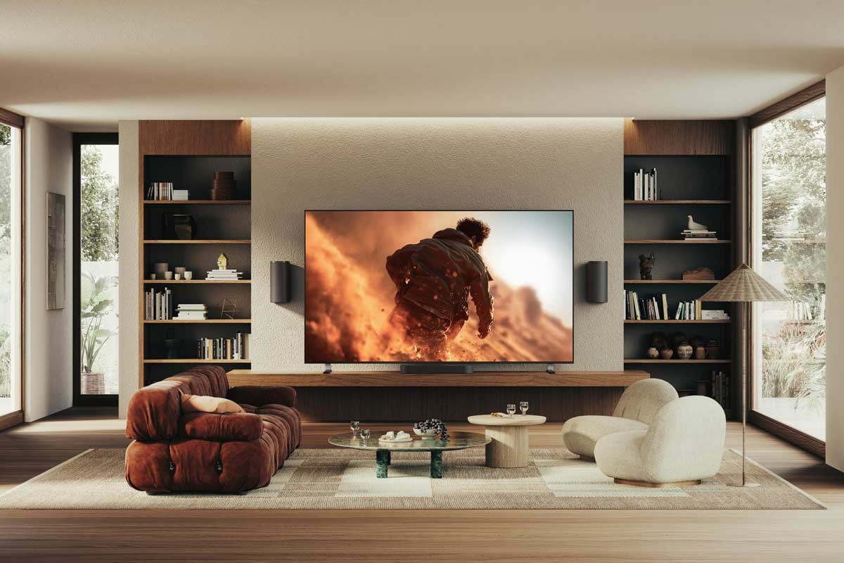 Modernes Wohnzimmer mit großem Fernseher und Regalen.