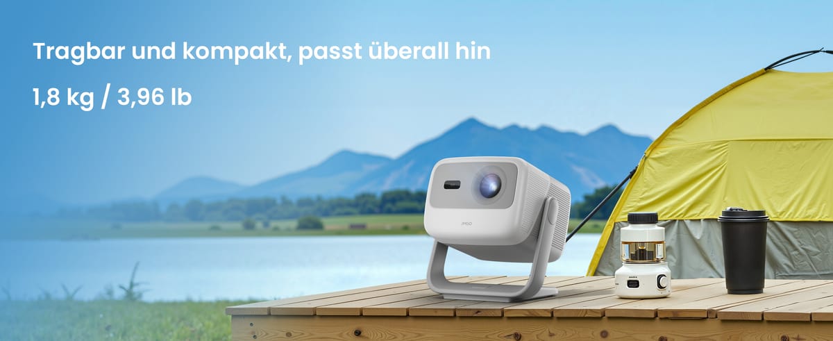 Tragbarer Beamer neben Zelt und See.