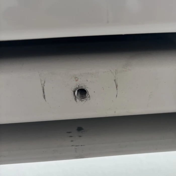 Kratzer unten am weißen Gehäuse rechts rund um ein Schraubloch