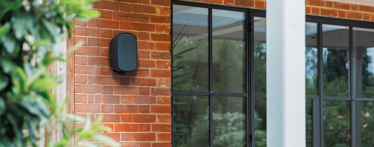 Außenlautsprecher an einer Backsteinwand montiert.