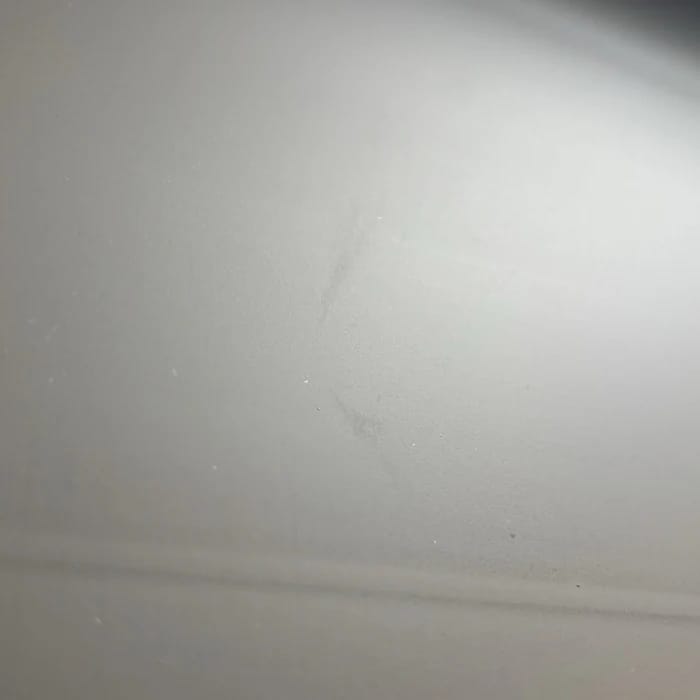 Kratzer im Tuch, darunter eine waagerechte Knicklinie