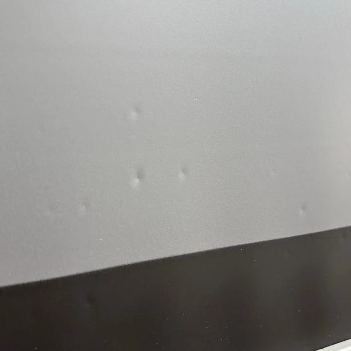 Mehrere kleine Dellen im Tuch über dem schwarzen Rand