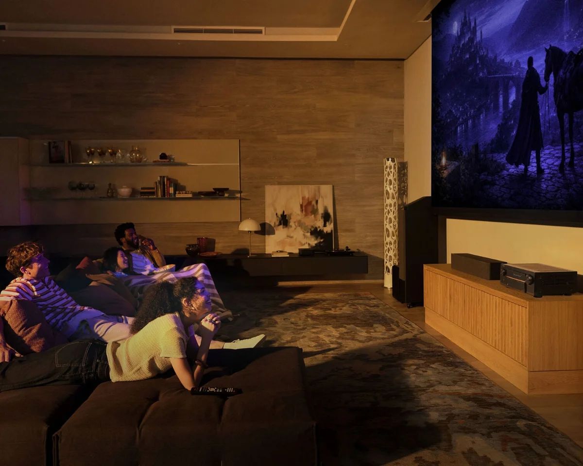 Heimkino mit Leinwand, Sofa und dem AV-Verstärker auf dem Sideboard