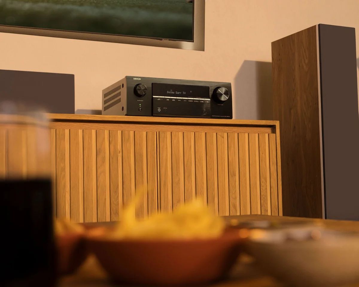 AV-Receiver auf einem Sideboard im Wohnzimmer, davor Snacks