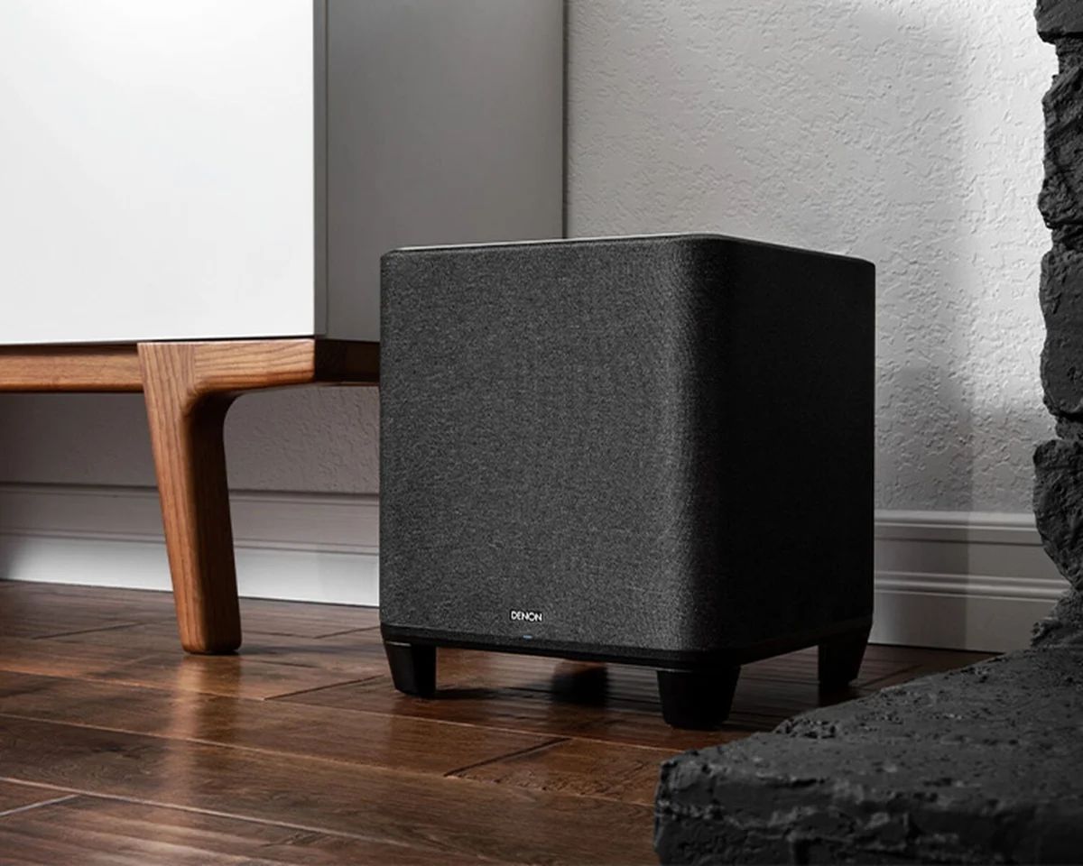 Subwoofer neben einem Holzmöbel im Wohnzimmer