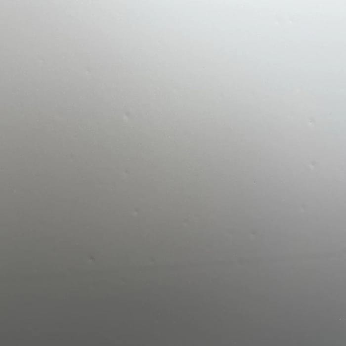 Mehrere kleine Dellen im Tuch, im Streiflicht sichtbar