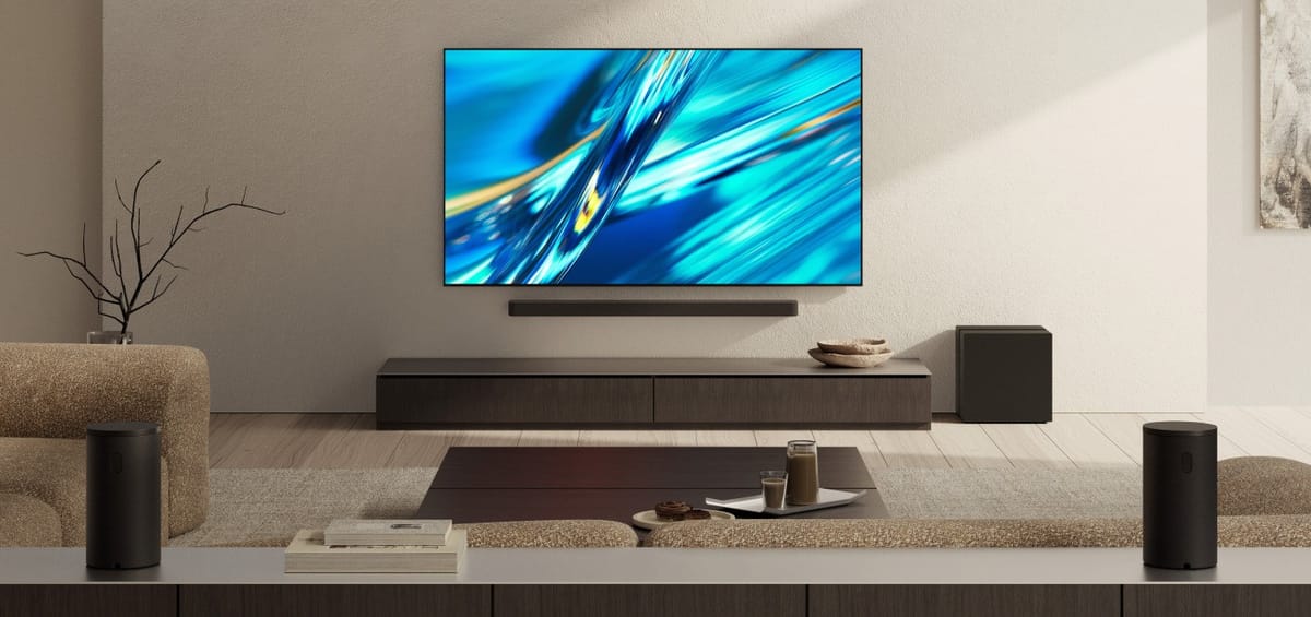 Modernes Wohnzimmer mit großem Fernseher und Lautsprechern.