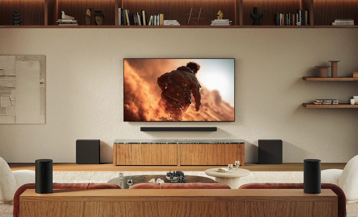 Modernes Wohnzimmer mit großem Fernseher und Lautsprechern.