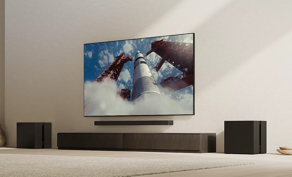 Wohnzimmer mit großem Fernseher und Lautsprechern.