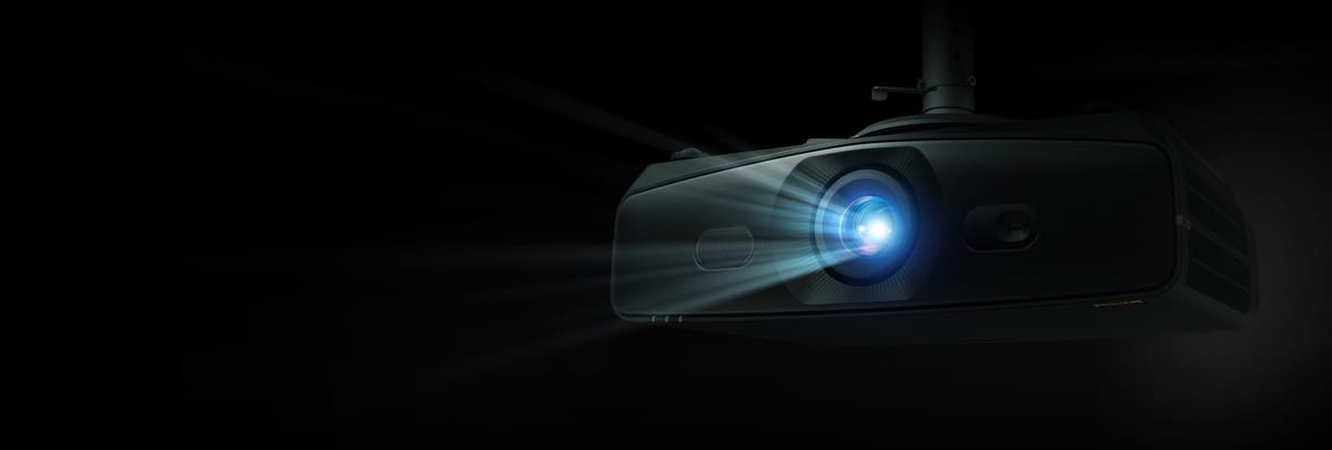 Beamer strahlt Lichtstrahl in dunklem Raum.