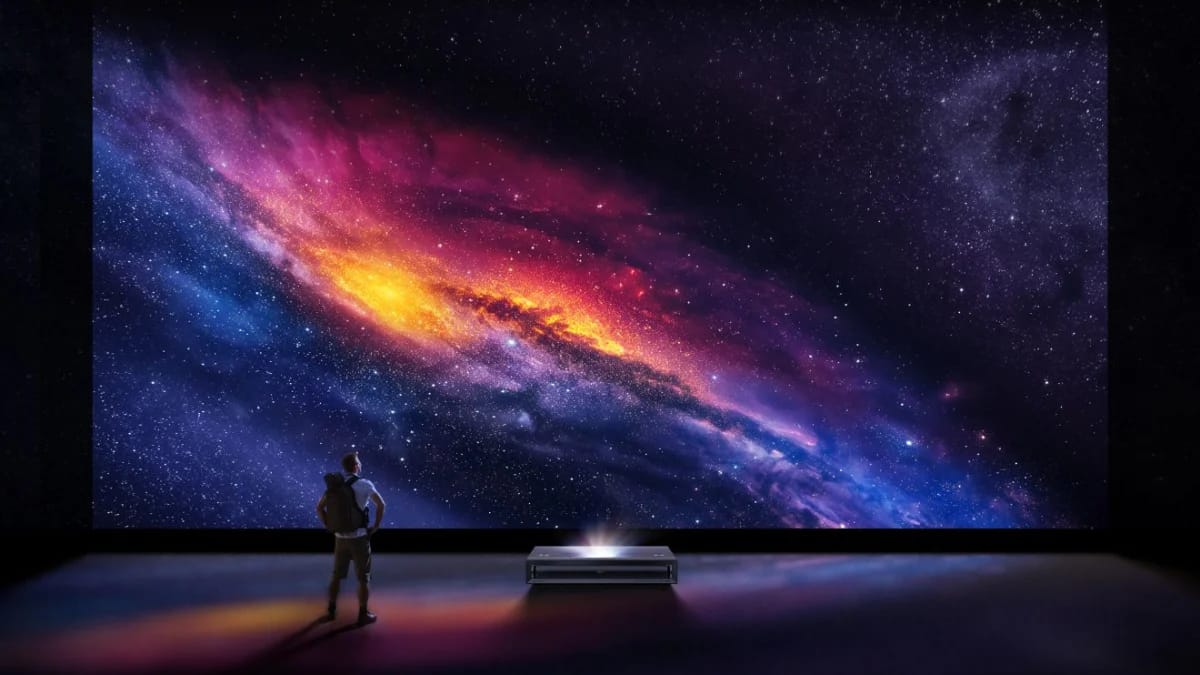 Galaxie-Motiv als großes Projektionsbild an der Wand, davor eine Person