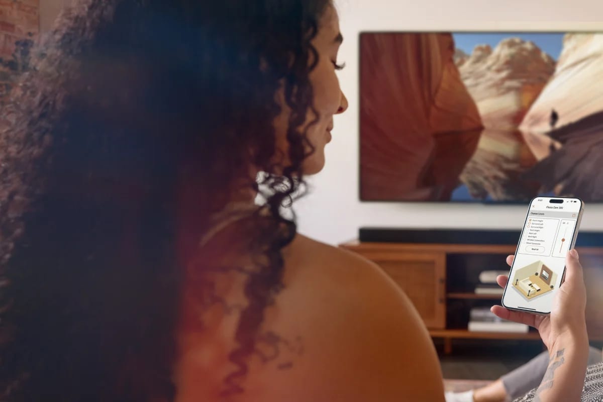 Frau steuert die Soundbar mit der App Klipsch Connect Plus