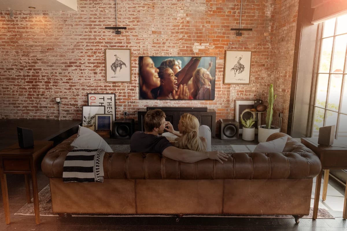 Wohnraum mit Ziegelwand, Sofa und Soundbar unter dem Fernseher