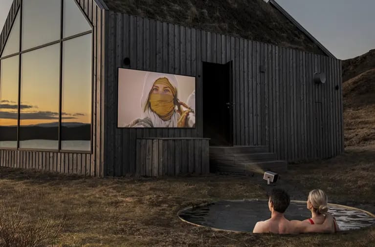 Paar schaut Film im Freien mit Beamer.