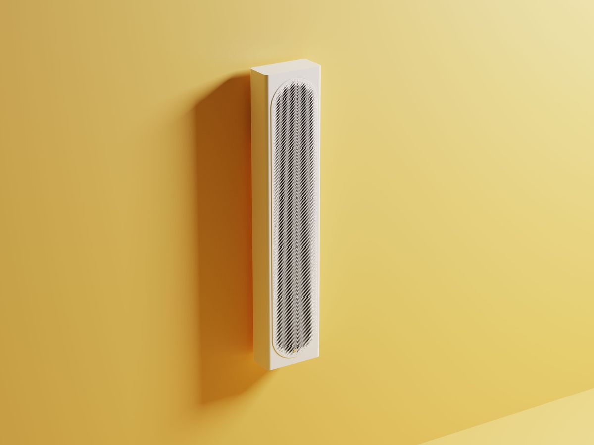 Weißer Beamer an gelber Wand montiert.