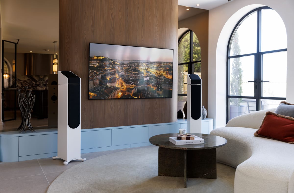 Modernes Wohnzimmer mit Fernseher und Lautsprechern.