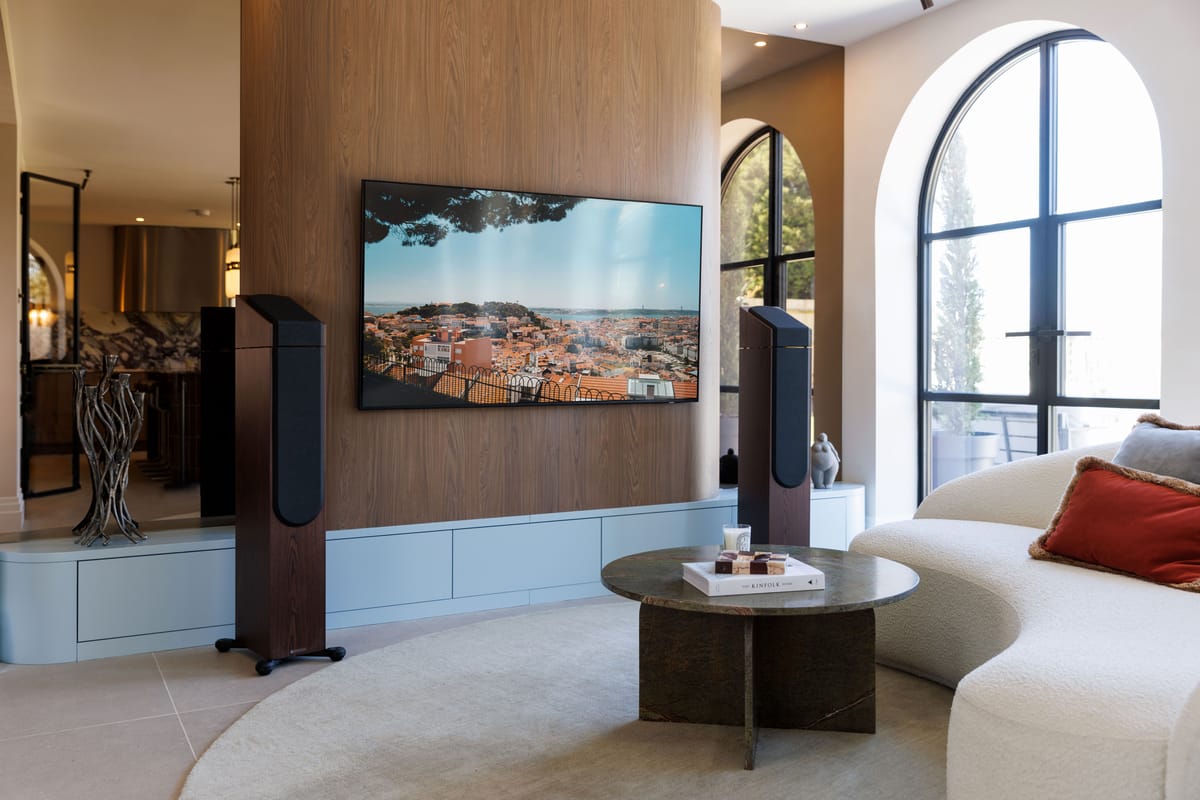 Modernes Wohnzimmer mit Fernseher und Lautsprechern.