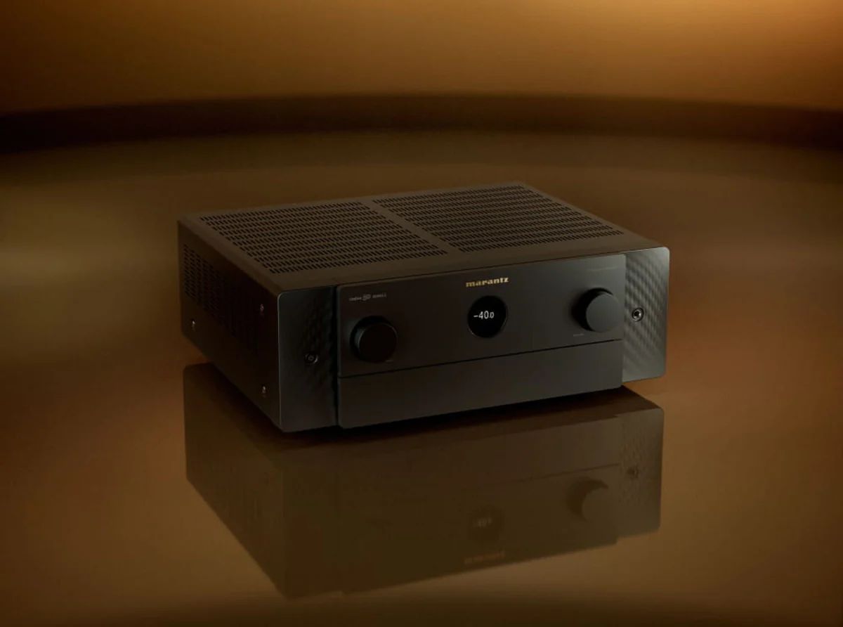 Schwarzer AV-Verstärker schräg auf einer spiegelnden Fläche vor braunem Hintergrund