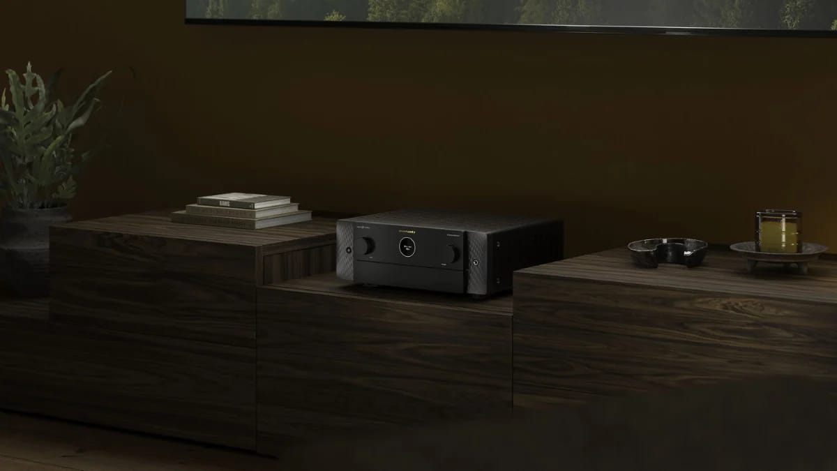 Schwarzer AV-Verstärker auf einem dunklen Holz-Sideboard im Wohnzimmer