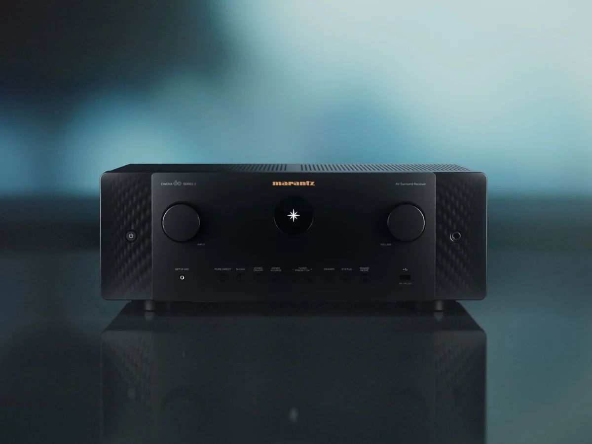 AV-Receiver in Schwarz von vorn auf spiegelnder Fläche, bläulicher Hintergrund