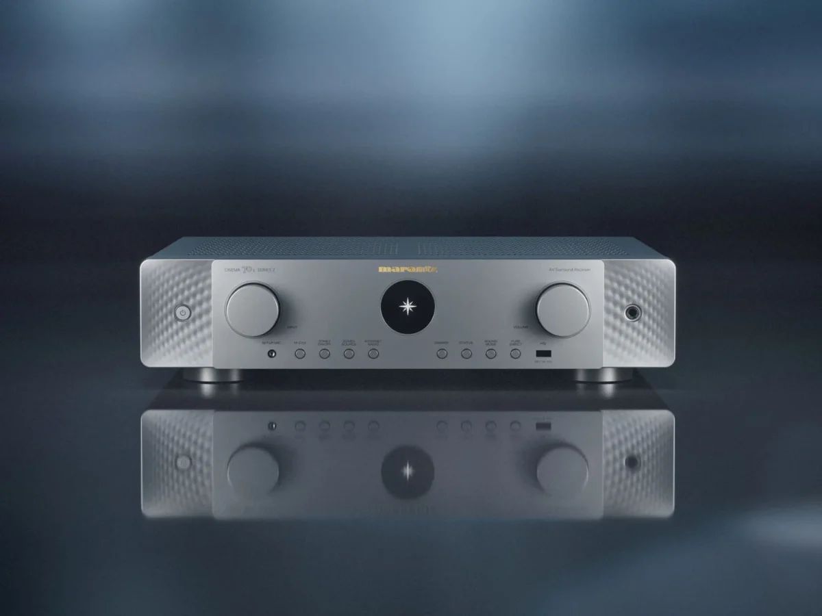 AV-Receiver in Silber-Gold frontal auf einer spiegelnden Fläche