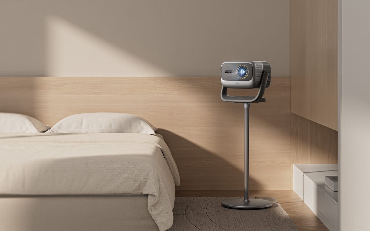 Beamer auf Ständer neben einem Bett.