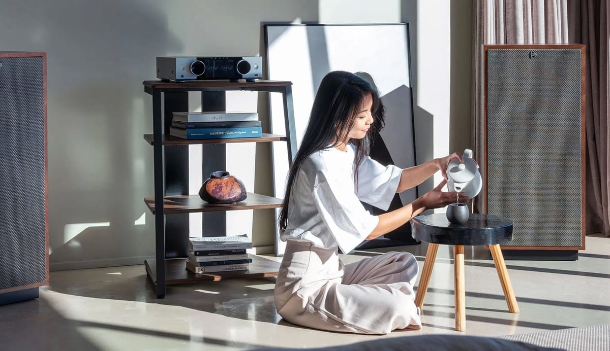 Frau gießt Tee in modernem Wohnzimmer.