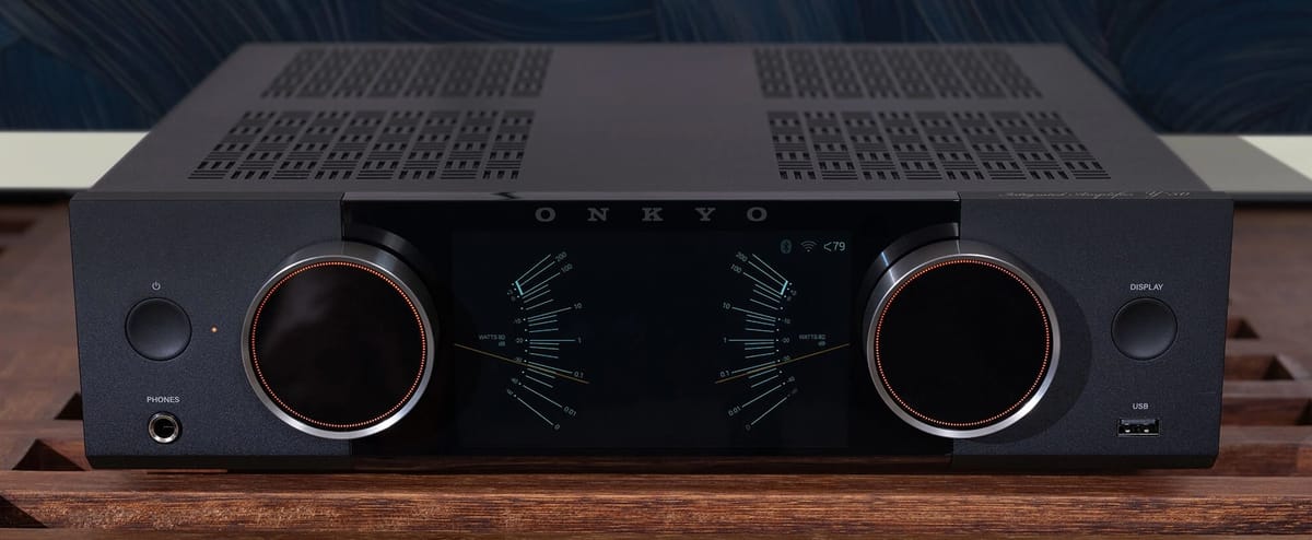 Schwarzer Onkyo-Verstärker auf Holztisch.