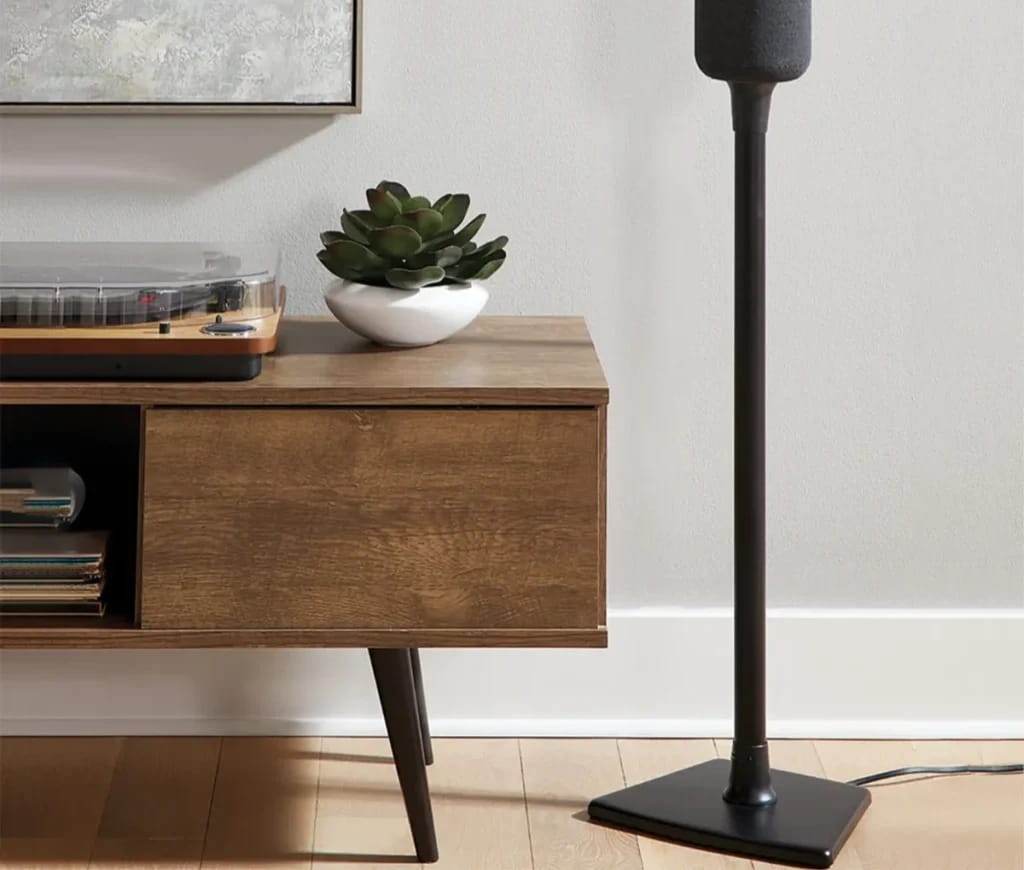 Lautsprecherständer mit Lautsprecher neben dem Sideboard.