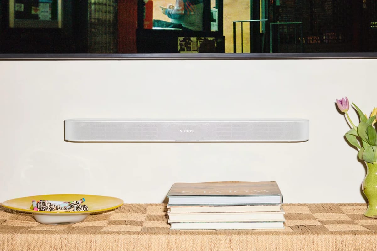 Weiße SONOS Beam Ultra an der Wand unter dem Fernseher.