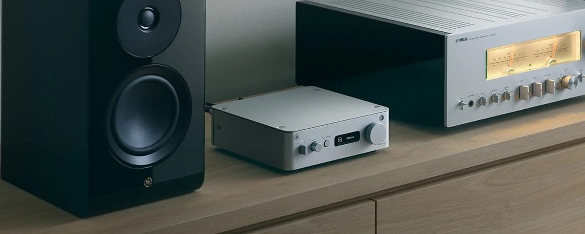 Yamaha WXC-70A Netzwerk Streamer in Silber neben einem HiFi-Verstärker