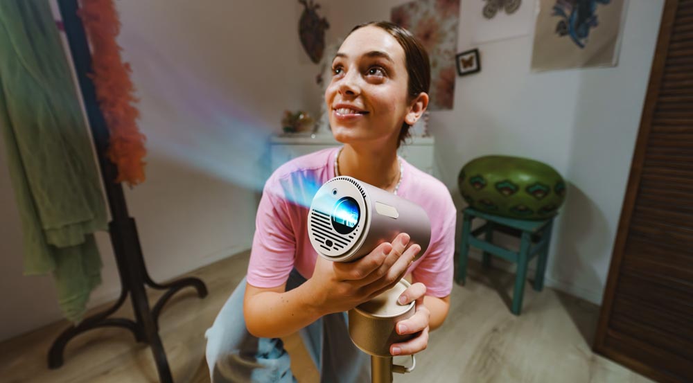 Frau hält Beamer in einem Raum.