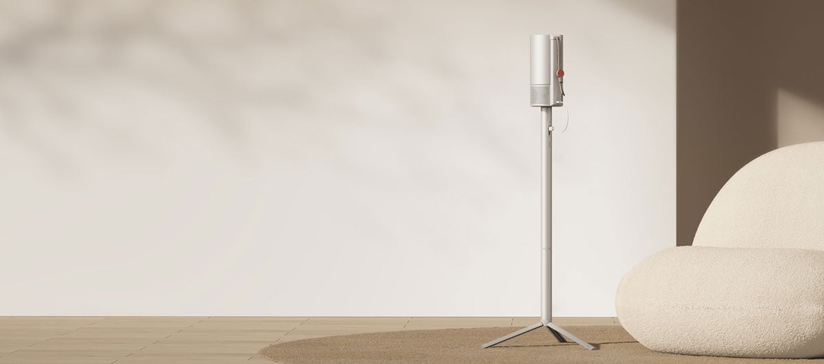 Moderner Beamer auf Ständer neben Sessel.