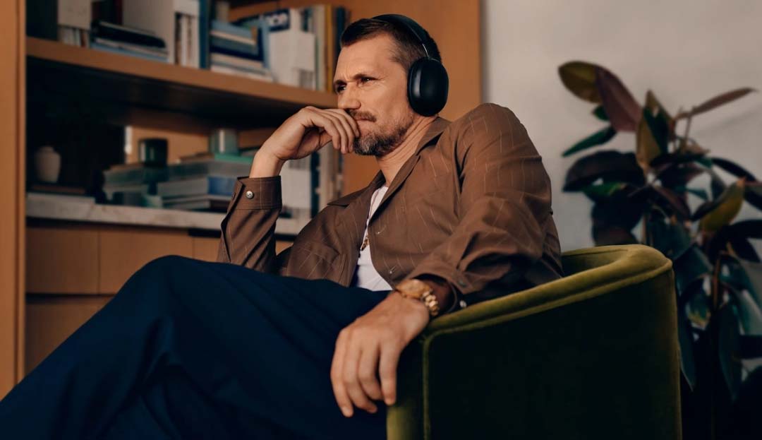 Mann mit Kopfhörern sitzt nachdenklich im Sessel.
