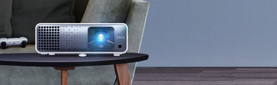 Beamer auf Tisch neben Sofa und Controller.